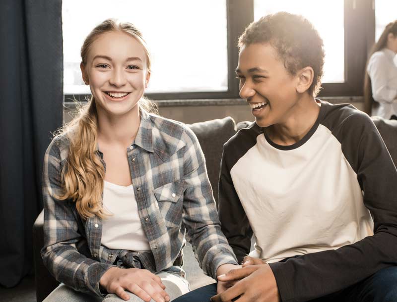 Teenagers smiling and holding hands